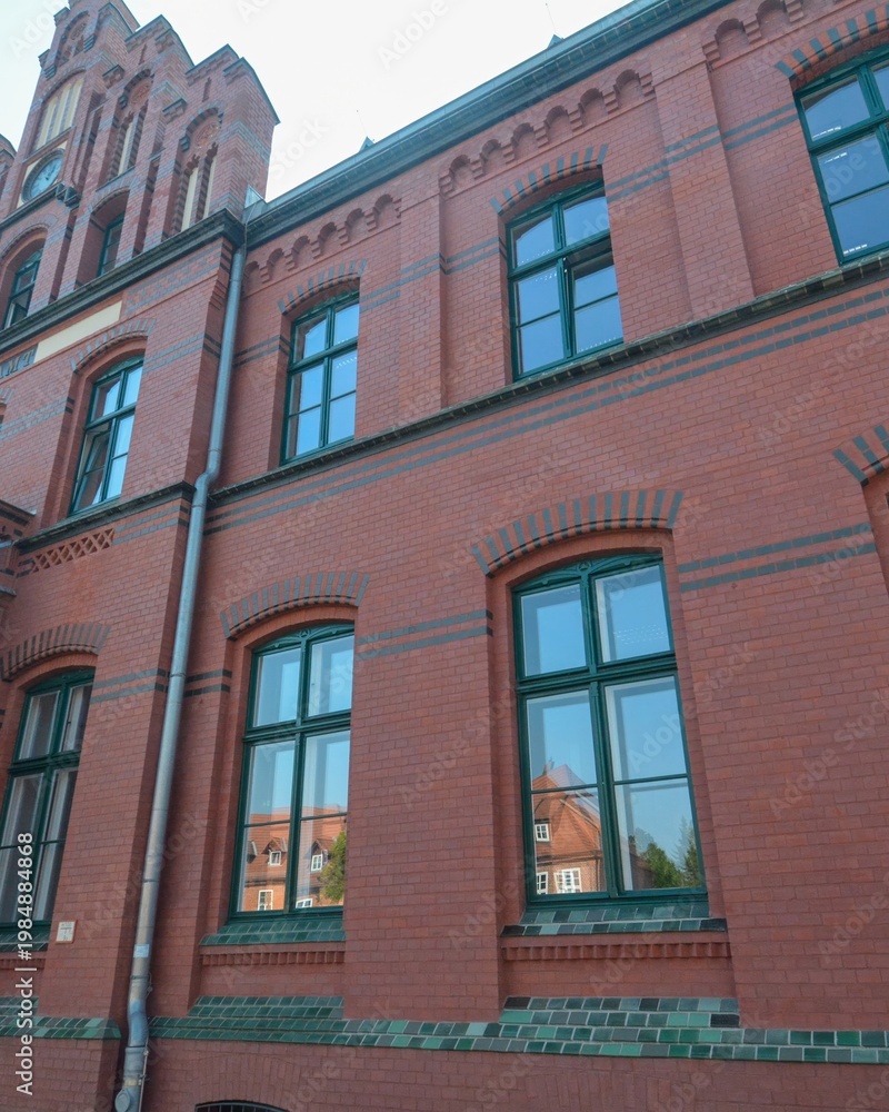 Fototapeta premium Ludwigslust brick facade with green windows reflecting architecture