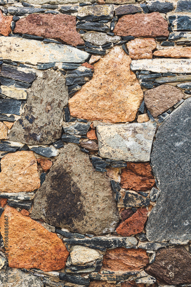 Fototapeta premium Rustic rubble stone wall in orange and grey front view portrait