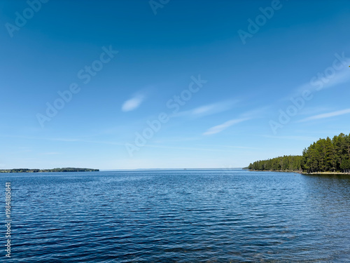Vast blue lake under a clear sky with distant islands