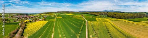 A bird's-eye view of the Taunus landscape awakening in spring, with blossoming trees and yellow rapeseed fields.