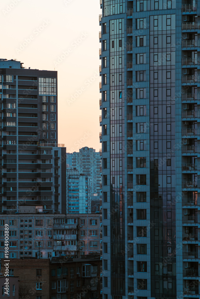 Fototapeta premium Serene layered perspective of urban apartment buildings under soft peach sky
