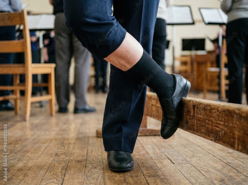 Fototapeta premium Choir member rehearsing while standing. This middle-aged man with fair skin wears dark trousers and rests his foot on a bench.