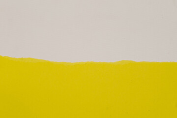 The background is a sheet of yellow paper with the top appearing to be torn horizontally, revealing a white or pale cream background underneath.