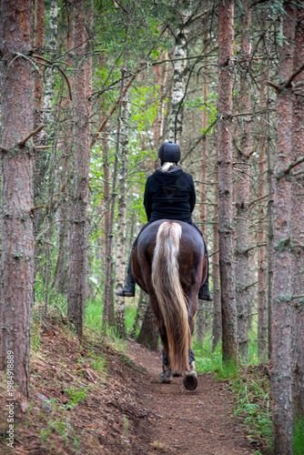 Woman horseback riding in the forest