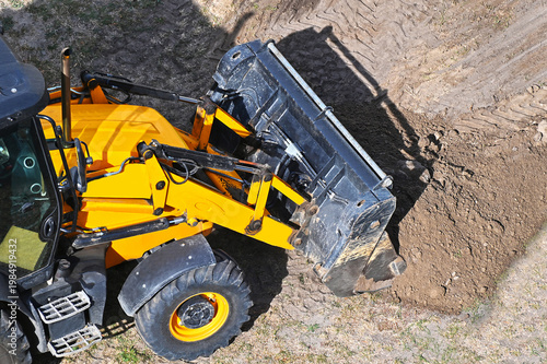 Backhoe loader loading soil
