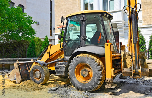 Backhoe loader on road construction