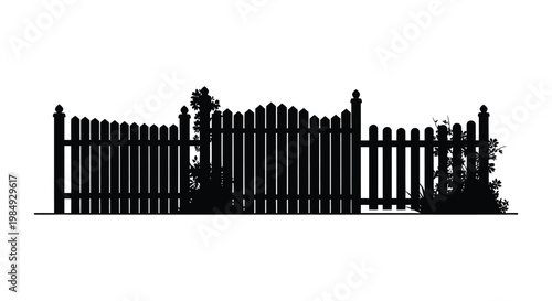 Black picket fence with foliage creating a striking garden scene silhouette