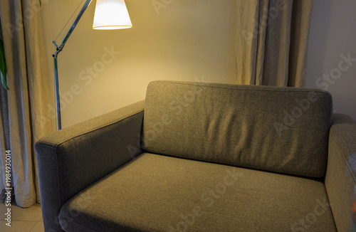 Modern living room interior with gray sofa, floor lamp, and neutral tones, minimalist design, cozy atmosphere