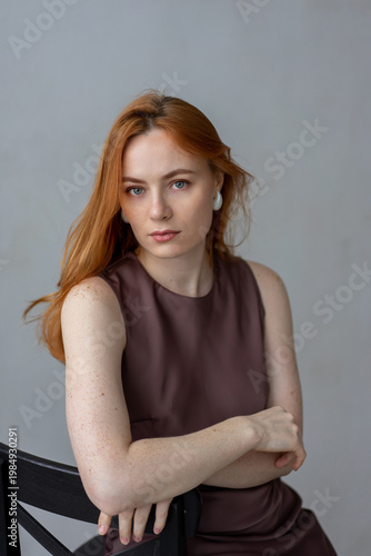 Portrait of young redhead woman with freckles in studio. Sensual expressive happy woman