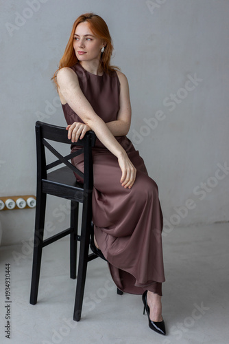 Portrait of young redhead woman with freckles in studio. Sensual expressive happy woman