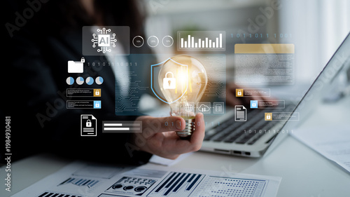 Tableau sur toile Image shows a business professional holding a light bulb, representing innovative ideas, while surrounded by digital data graphics and security elements in a modern office setting