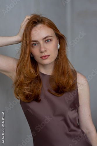Portrait of young redhead woman with freckles in studio. Sensual expressive happy woman