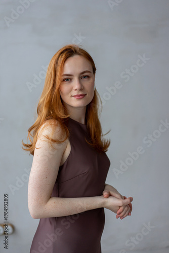 Portrait of young redhead woman with freckles in studio. Sensual expressive happy woman