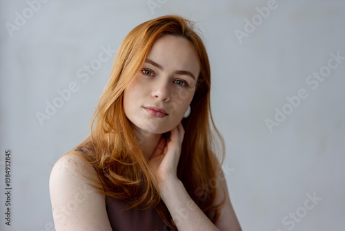 Portrait of young redhead woman with freckles in studio. Sensual expressive happy woman