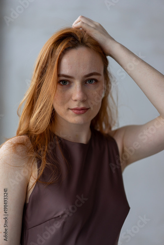 Portrait of young redhead woman with freckles in studio. Sensual expressive happy woman