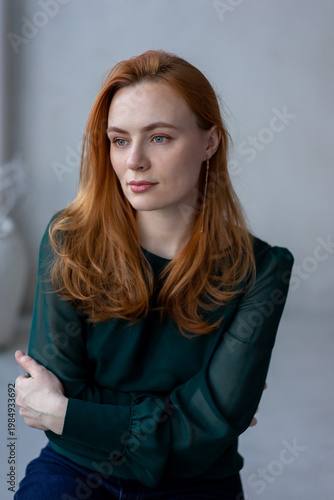 Portrait of young redhead woman with freckles in studio. Sensual expressive happy woman
