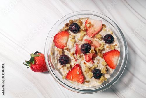Oatmeal porridge with strawberries, blueberries and nuts