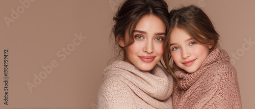 warm mother and daughter portrait in cozy knit sweaters with soft studio background