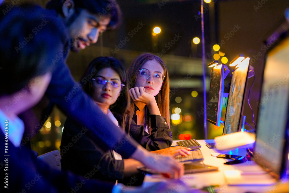 Fototapeta premium Focused cybersecurity specialist analyzing real time threat intelligence on multiple monitors. Diverse IT squad managing zero trust network and cloud native security in a glowing tech command center.