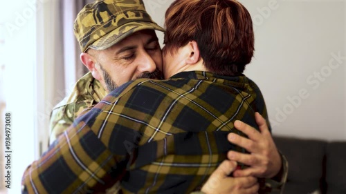Happy military man hugging his wife at home - Welcome home and family love concept