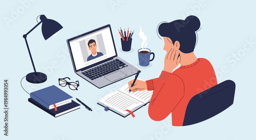 A person participates in an online video call while studying at a desk with a laptop, notebook, and lamp.