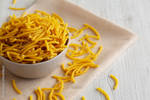 Organic Dry Raw Macaroni Pasta in a Bowl, side view.