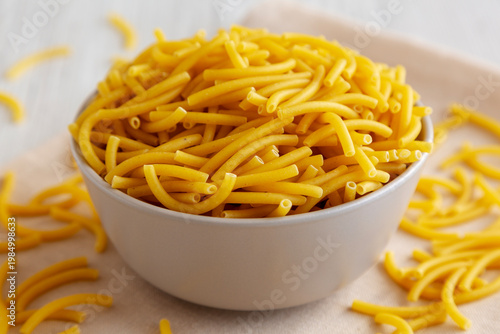 Organic Dry Raw Macaroni Pasta in a Bowl, side view.