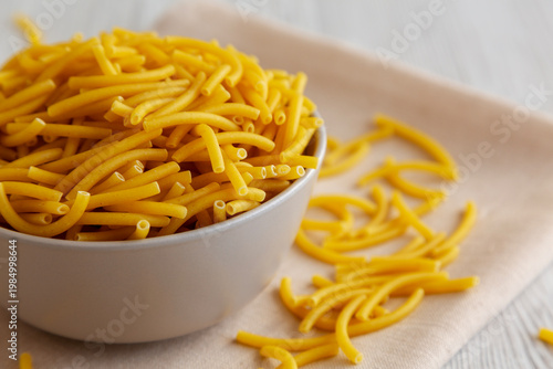 Organic Dry Raw Macaroni Pasta in a Bowl, side view.