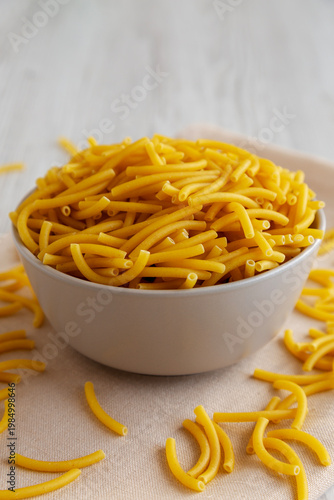 Organic Dry Raw Macaroni Pasta in a Bowl, side view.