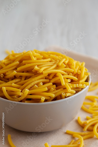 Organic Dry Raw Macaroni Pasta in a Bowl, side view.