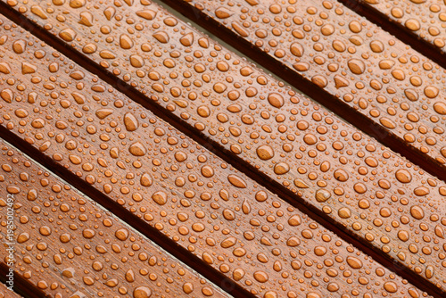 Close-up of rain droplets on a wet wooden table surface