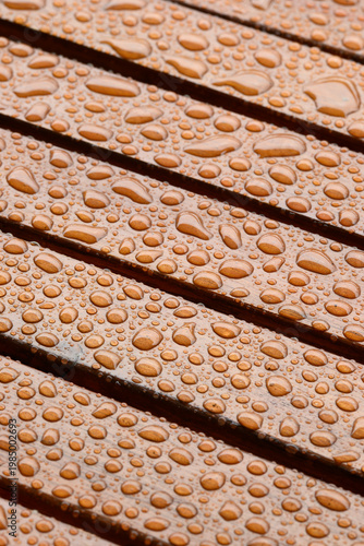 Close-up of rain droplets on a wet wooden table surface