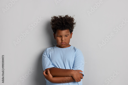 Cuadro en lienzo Resentful little boy with crossed arms on grey background