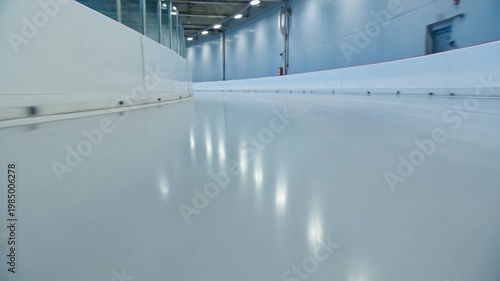 POV Curving Through an Indoor Ice Track With Smooth White Barriers and Crisp Reflections