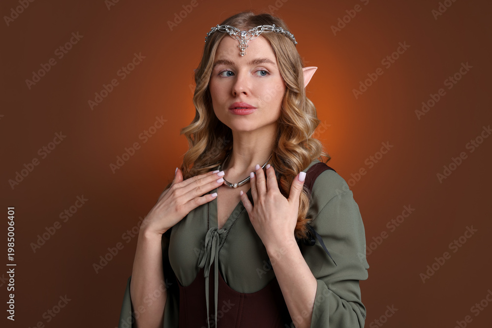 Fototapeta premium Portrait of beautiful elf girl on brown gradient background