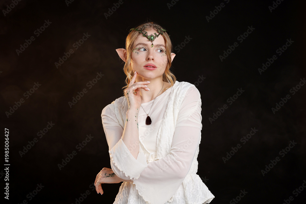 Fototapeta premium Beautiful girl dressed as elf on black background with smoke