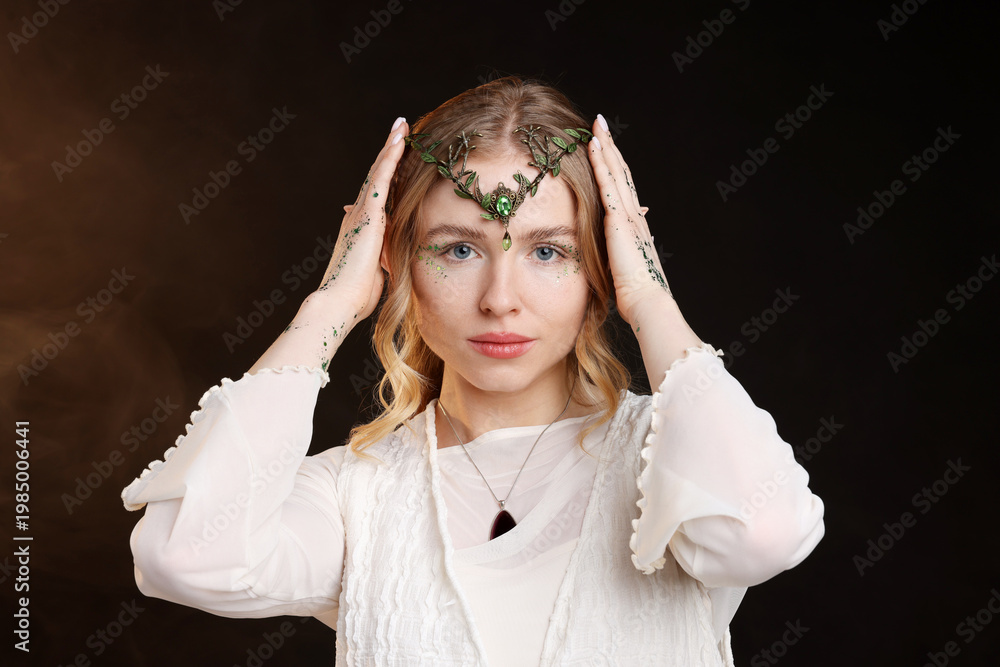 Fototapeta premium Beautiful girl dressed as elf on black background with smoke