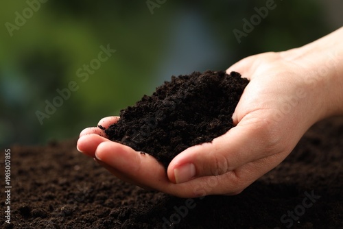 Woman with fresh soil on blurred background, closeup