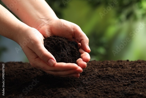 Woman with fresh soil on blurred background, closeup