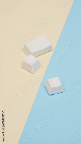 Cubed candies in different colors against a yellow strip and blue backdrop.