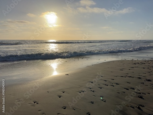 Foto A wide view of a dramatic, steely sunset over the Pacific Ocean at Carlsbad State Beach, with wet sand reflecting the twilight sky