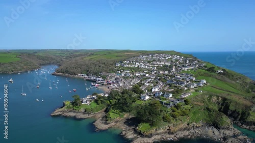 Polruan, Cornwall, England: DRONE VIEWS: A reveal shot of Polruan village as the drone rises over the River Fowey. Polruan is a river ferry crossing point and a popular UK holiday destination.