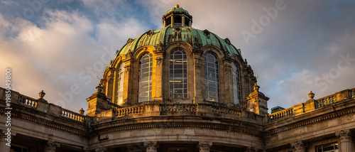Ornate cathedral with stained glass windows and gold accents as the sun sets.