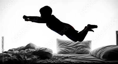 A silhouette of a boy jumping on a bed with a white background