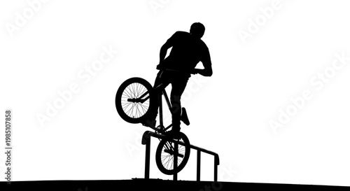A silhouette of a man performing a trick on a bicycle against a white background