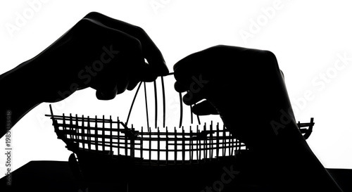 A silhouette of two hands manipulating strings attached to a marionette puppet on a white background