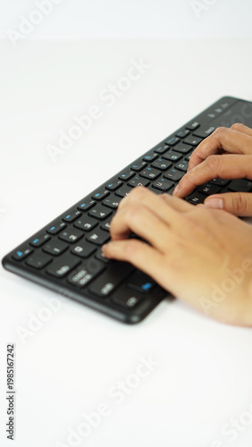 vertical position of gesture 10 fingers of a woman's hand are on the letter keys on a black wireless keyboard as a sign of typing, isolated on a white background