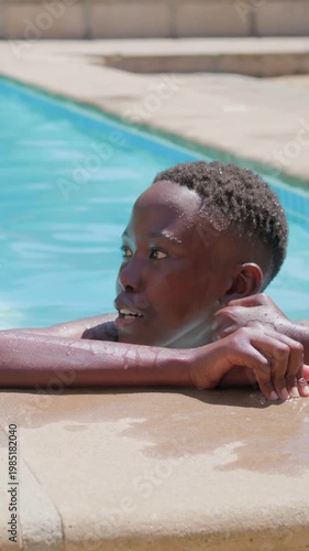 Vertical video: Turning teen shirtless at pool edge, rubbing face and smiling at adult appearing