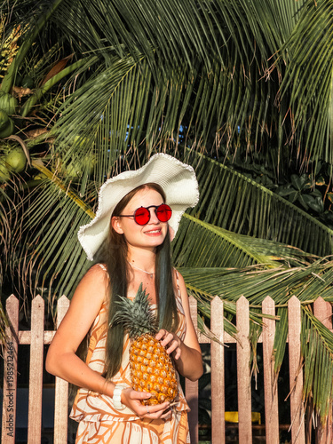 Fresh pineapple in hands on sunny beach. Concept healthy nutrition, natural vitamins and organic tropical food, refreshing summer snack, exotic lifestyle, wellness inspiration and clean eating habits