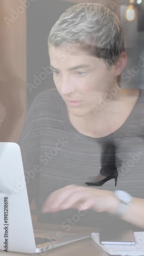 Vertical video: Worker placing hands on laptop while typing, heels moving across frame, tech work